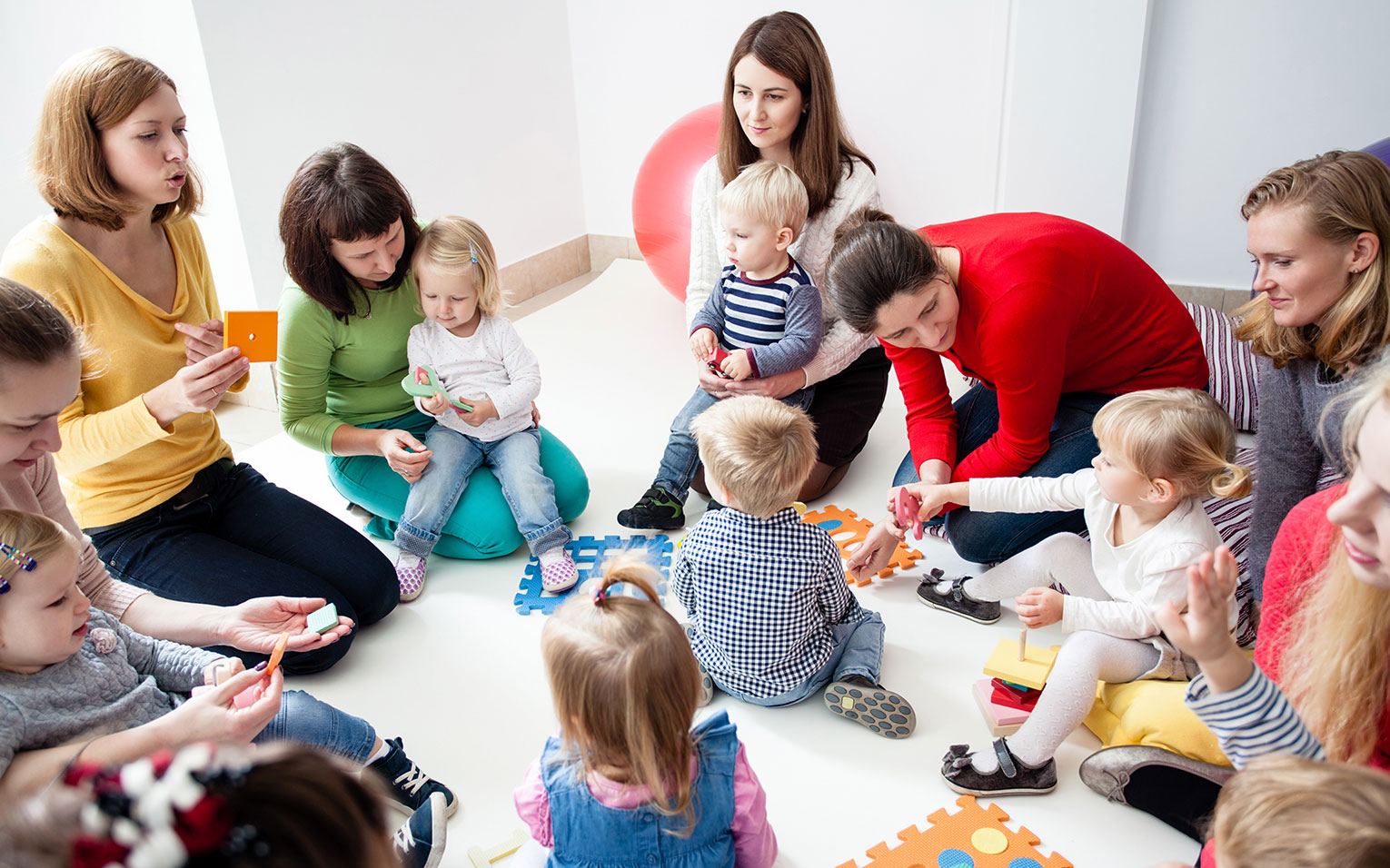 Unser neues Programm Herbst/Winter 2021/2022 ist online! Gruppe mit Eltern und Kindern am Spielen